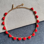 Heart-shaped necklace with gold chain and red enamel heart charms