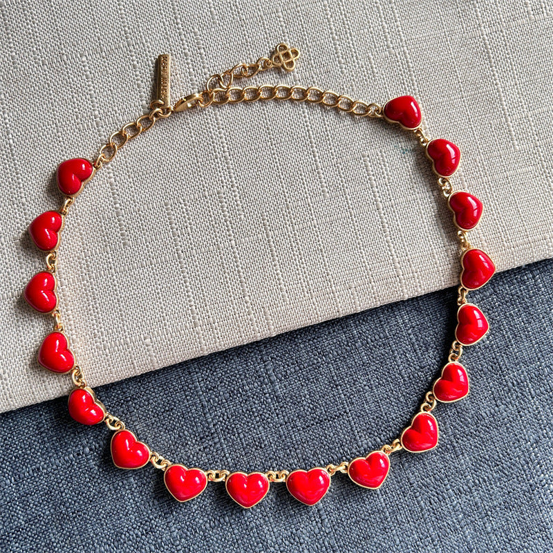 Heart-shaped necklace with gold chain and red enamel heart charms