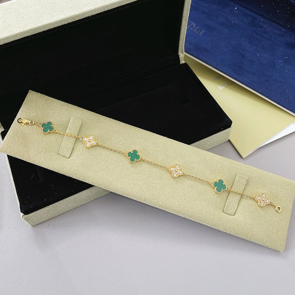 Goldfarbenes Kleeblatt-Armband mit grünen Motiven und funkelnden Zwischenstücken, mit Verschluss