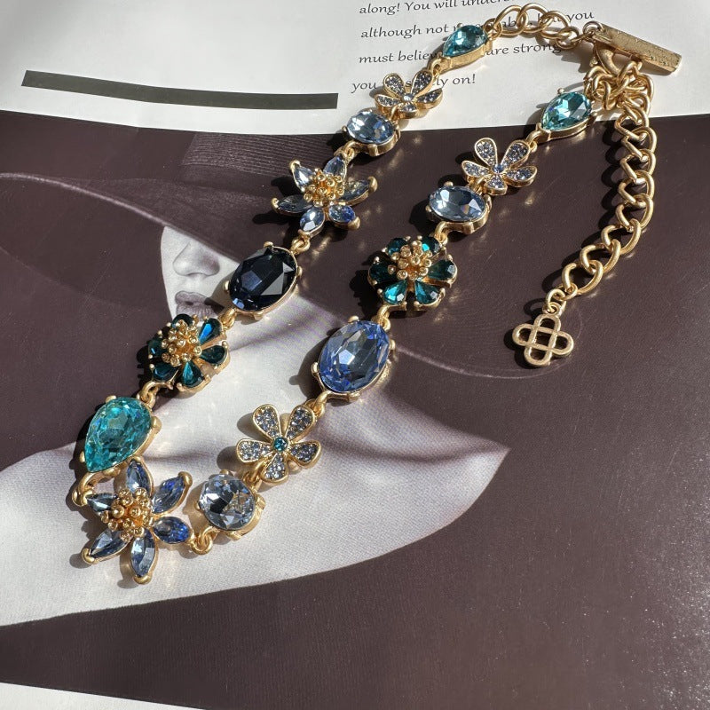 Goldfarbene Halskette mit blauen Zirkonia-Facettensteinen, Gliederkette und Blumen