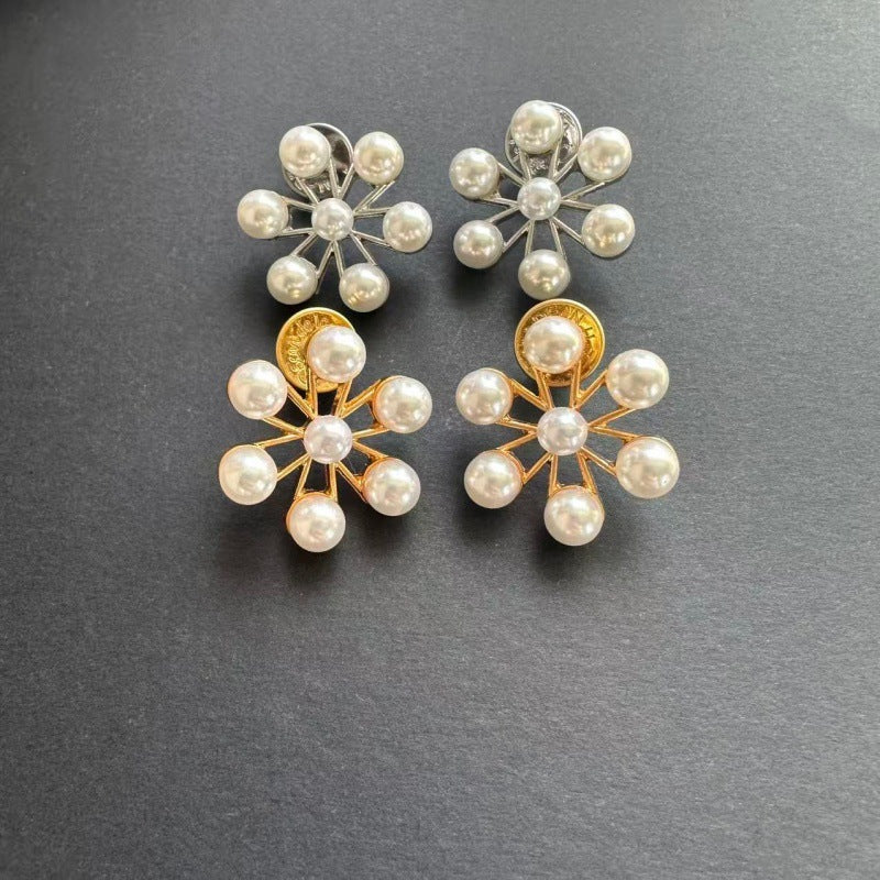 Ferris wheel pearl earrings pair: one gold-tone, one white gold-tone