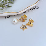 Gold asymmetrical earrings: heart charm with rhinestones and star charm with pearl drop