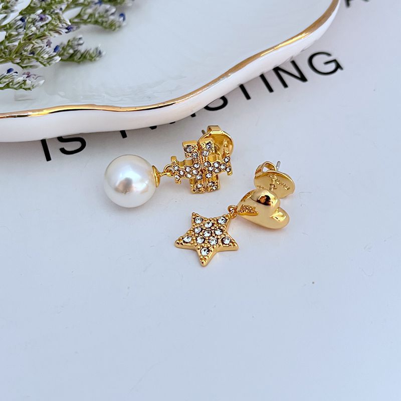 Gold asymmetrical earrings: heart charm with rhinestones and star charm with pearl drop