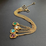 Gold-tone hammered square pendant necklace with multiple stones on chain, layered