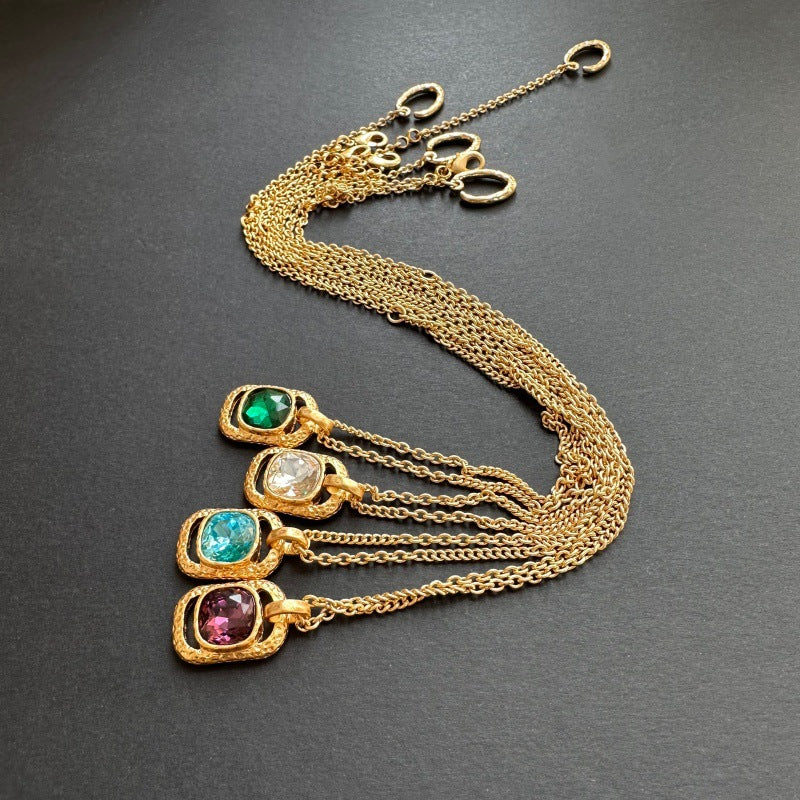 Gold-tone hammered square pendant necklace with multiple stones on chain, layered