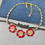Enamel cherry blossom pendant necklace with red flowers and gold-tone chain with clear rhinestones