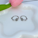 White gold hoop earrings with clover logo charm and beaded accents