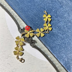 Gold-tone ladybug and four-leaf clover charm bracelet with clover and rose accents
