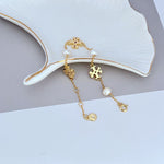 Gold-toned pearl bracelet with puzzle-shaped charms and visible extender clasp