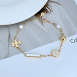 Tory Burch enamel agate logo bracelet in gold tone with white beads and puzzle charm