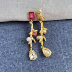 Clip-on earrings with gold branch design, pink-red stones, white pearls, and crystal drops