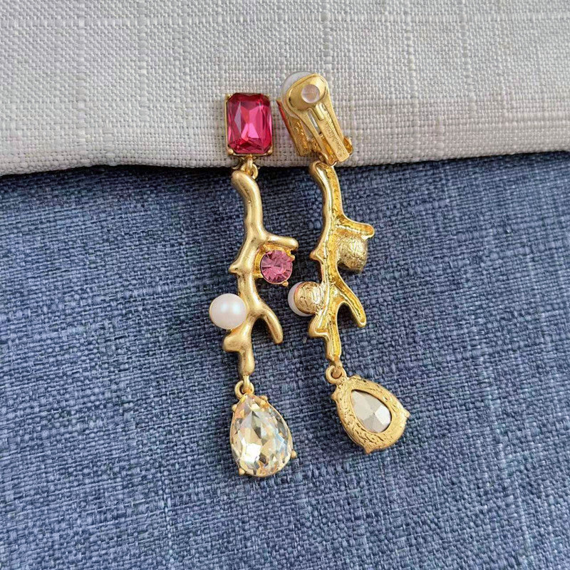 Clip-on earrings with gold branch design, pink-red stones, white pearls, and crystal drops