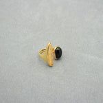Gold open ring featuring black oval cabochon and arched light marbled setting.