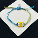 Pulsera ajustable bicolor azul-verde con dije esmaltado amarillo y charnela dorada