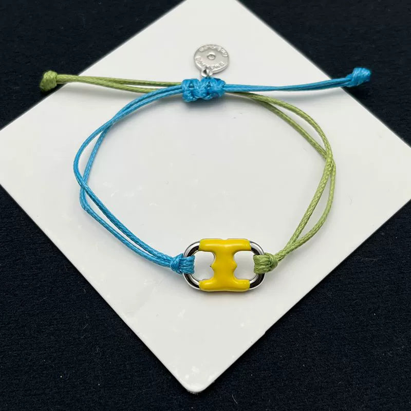 Pulsera ajustable bicolor azul-verde con dije esmaltado amarillo y charnela dorada