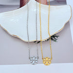 White gold and gold logo pendant necklace set with round openwork emblem on chains