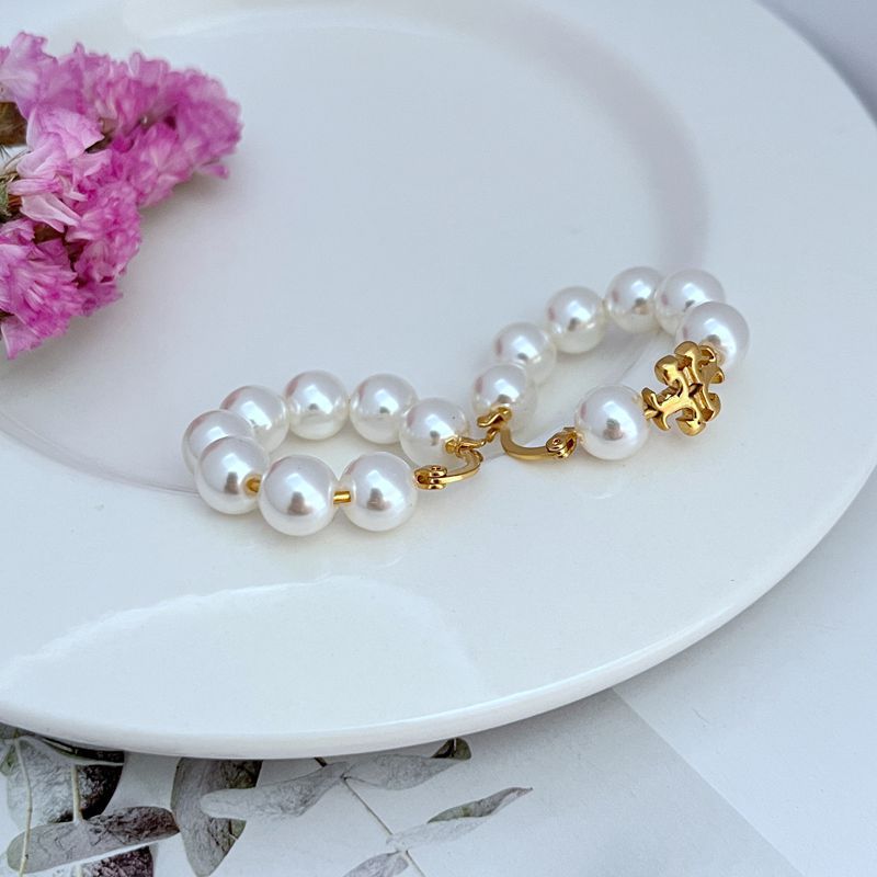 Round white pearl strand hoop earrings with gold clasp and small charm accents