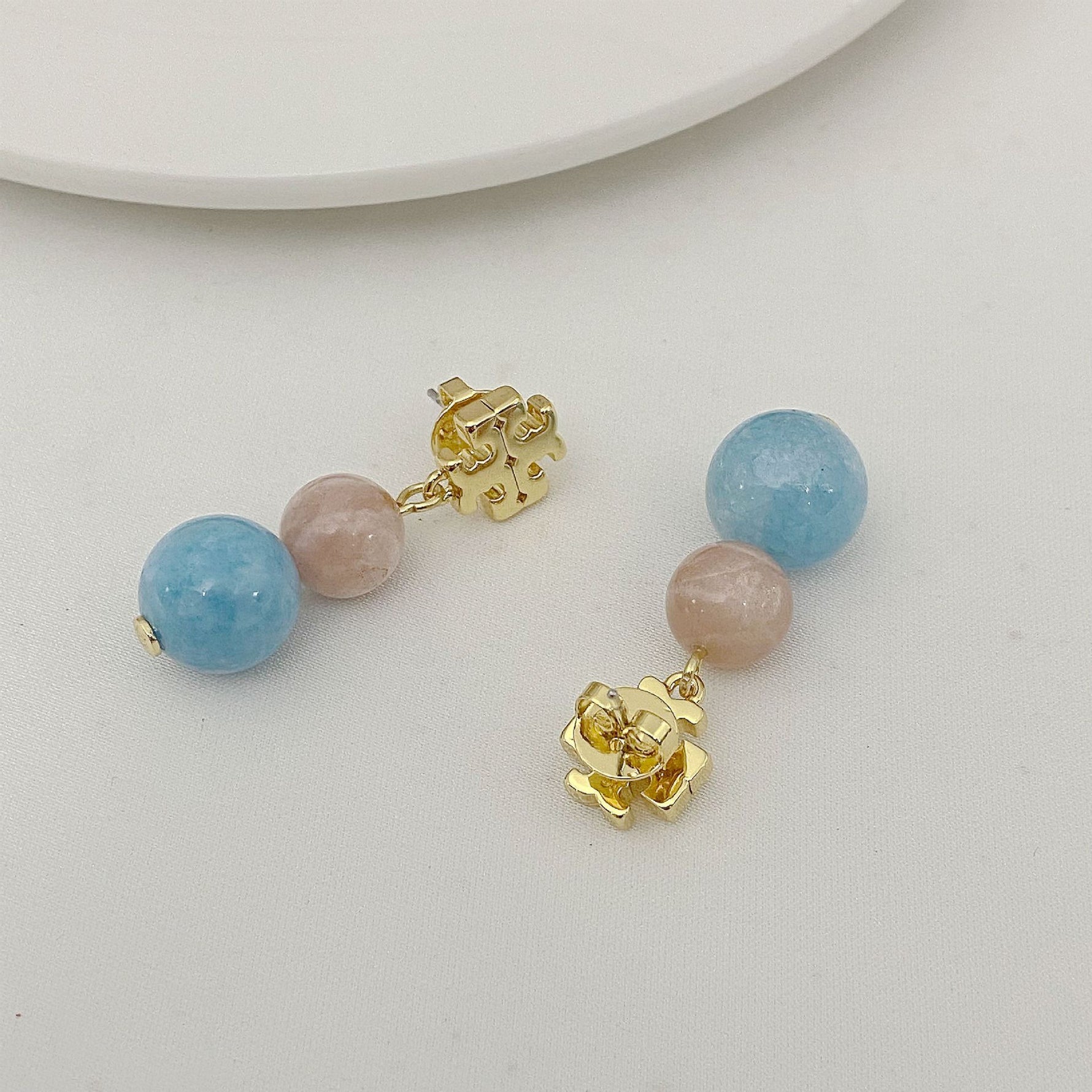 Logo-Perlen-Achat-Ohrstecker, hellblaue und rosafarbene Kugeln mit goldfarbenem Logo