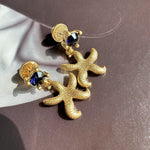 Oscar de la Renta vintage gold starfish stud earrings with dark blue crystals