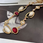 O-ring glass pearl necklace, deep red and pink accents with white oval pearls, gold tone