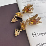 Gold-tone floral zircon drop earrings with amber teardrop stones