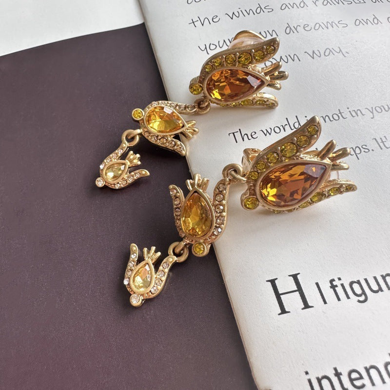 Gold-tone floral zircon drop earrings with amber teardrop stones