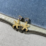 Gold starfish stud earrings with light-colored crystals