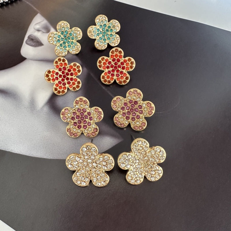 Set of colorful floral stud earrings: teal, red, pink, and clear stones on gold
