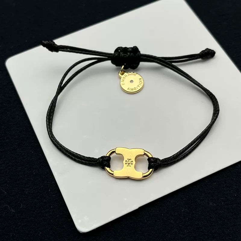 Pulsera ajustable con cordón negro y dije esmaltado dorado en amarillo