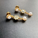 Gold-tone crystal drop earrings with pearl-like round accents and clear center stone