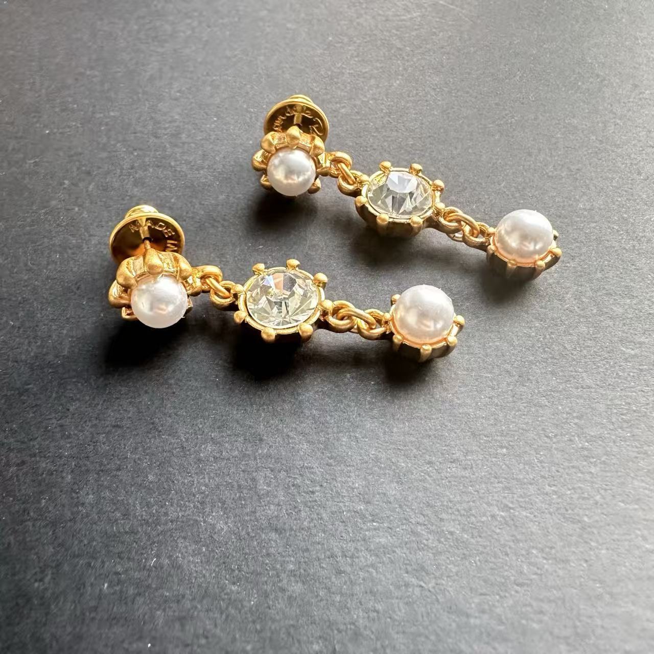 Gold-tone crystal drop earrings with pearl-like round accents and clear center stone