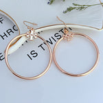 Large round rose gold hoop earrings with quatrefoil charm