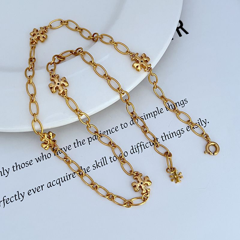 Interlocking logo bracelet, gold-tone oval links with clover centerpiece charms