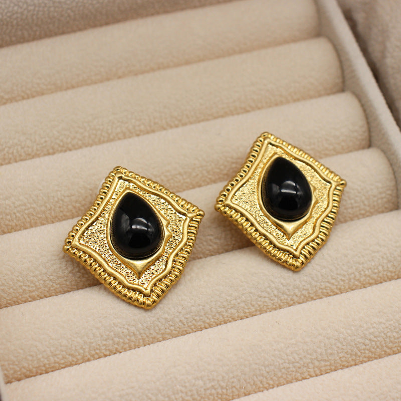 Hammered quadrilateral earrings with black teardrop stones in gold frames
