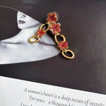 Gold floral drop earrings with red crystal clover and oval link drops