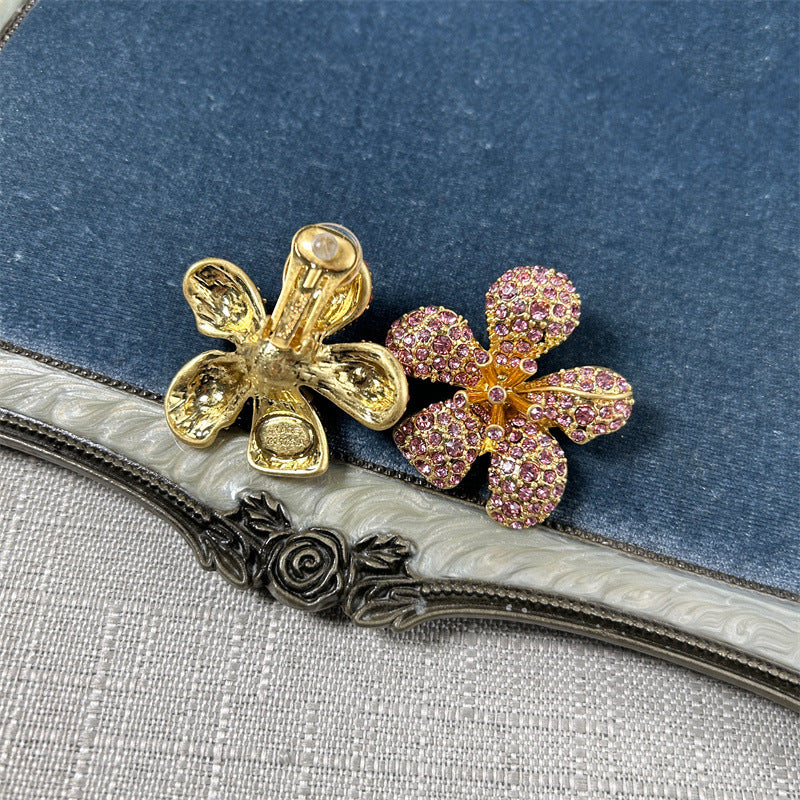 Gold-tone five-petal flower earrings with pink-purple crystal pavé petals