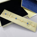Goldfarbenes Armband mit Kleeblatt-Motiven in Blau, Gliederkette mit Verschluss