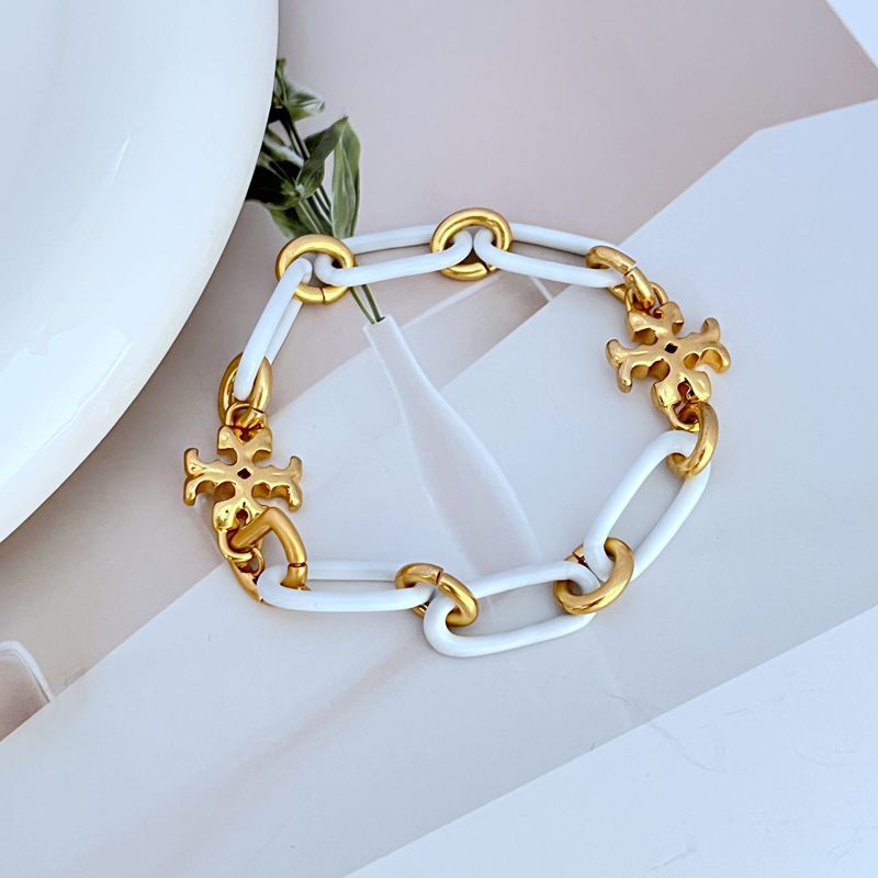 Chunky chain logo bracelet in white with gold-tone links and quatrefoil charms