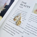 Gold-tone vintage tulip earrings with teardrop crystal centers and layered pearl dangles