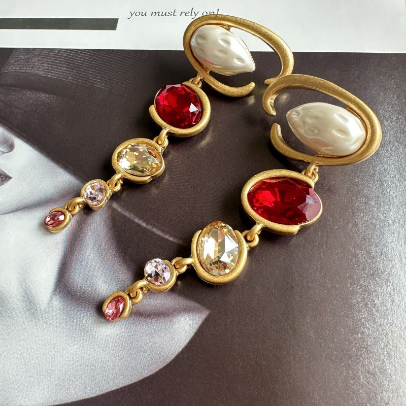 Long crystal drop earrings in gold with red crystals and clear champagne details