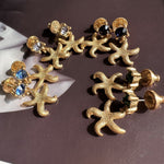 Gold starfish stud earrings with dark blue and clear crystals