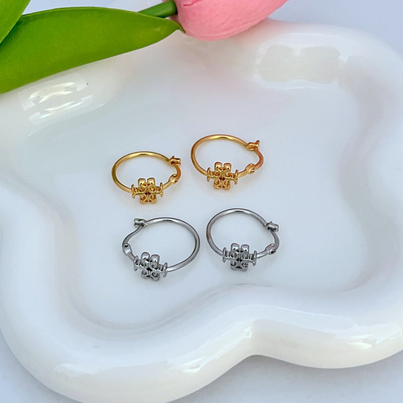 Gold and white gold hoop earrings with small clover logo charms