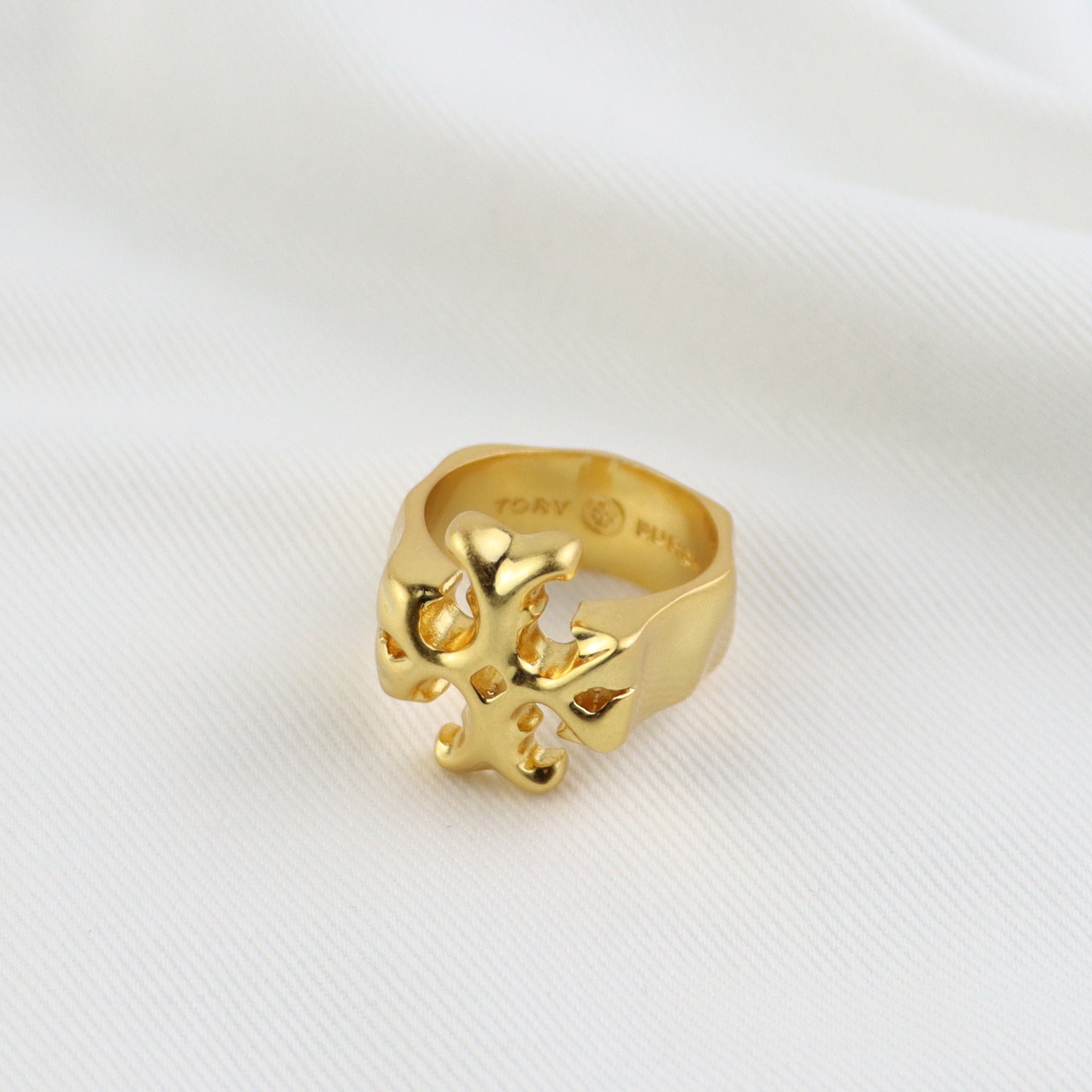 Matte gold vintage ring, angled side view with detailed cutout logo motif