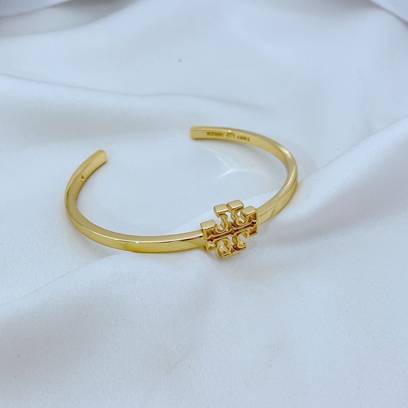 Gold smooth open metal bangle with square logo centerpiece and hinge