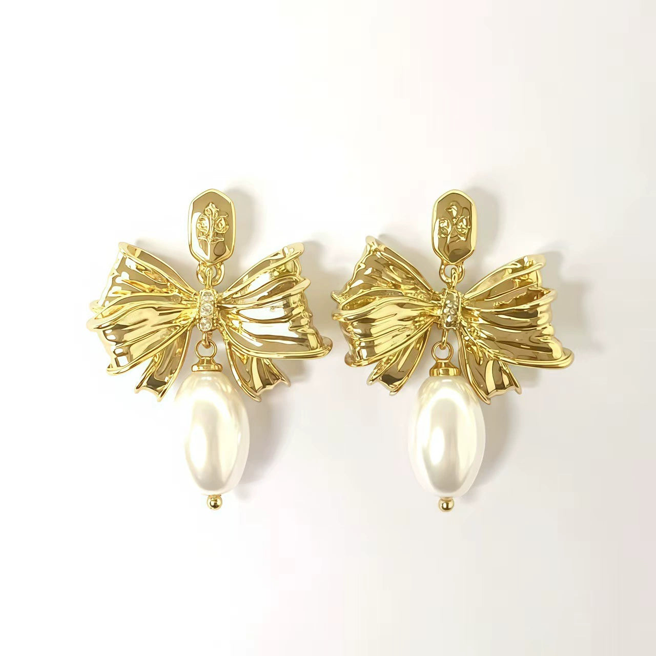 Gold-tone bow pearl drop stud earrings with white pearl and rhinestone center