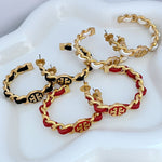 Logo hoop earrings, gold chain with red and black enamel accents