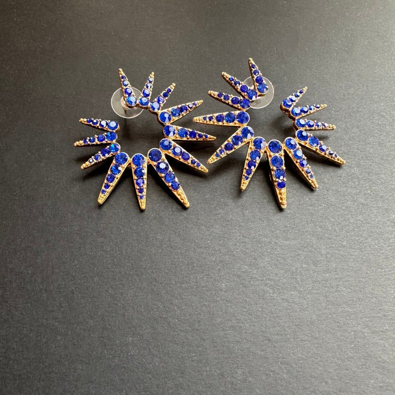 Blue diamond starburst sunflower earrings with gold-tone prongs and blue accents