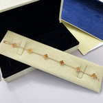 Gold-tone clover bracelet with red agate flower links and four-leaf pattern, clasp