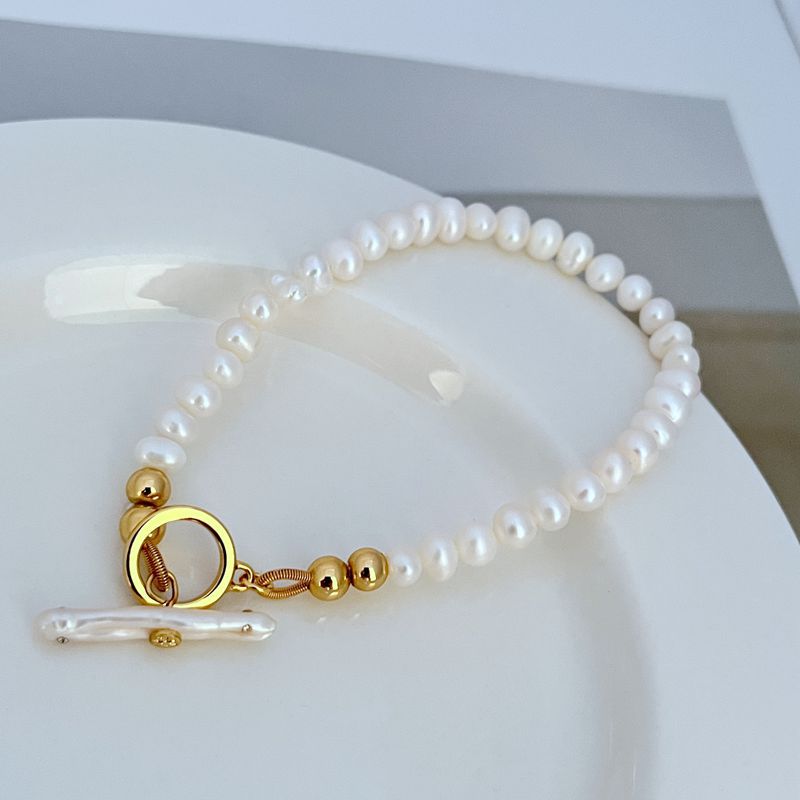 Pearl bead bracelet with gold ring clasp and spring clasp detail