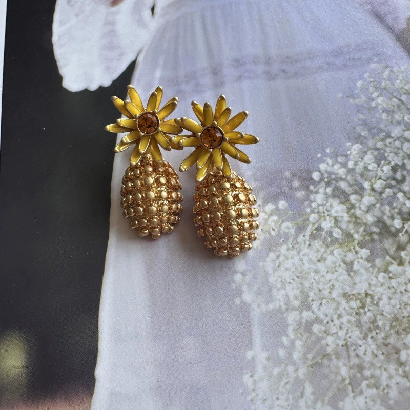 Gold enamel flower diamond earrings with gold textured pineapple drops and dark center stones
